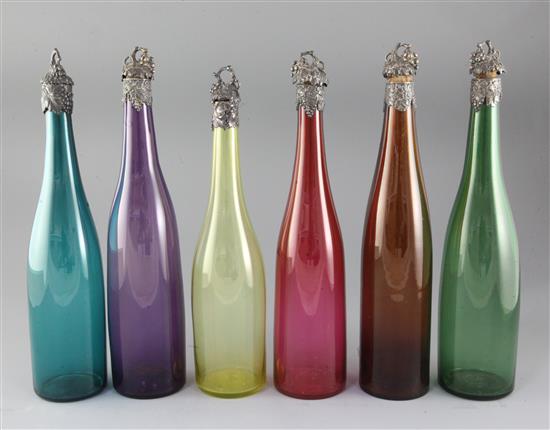 Six assorted coloured glass wine bottles with vineous collars and stoppers,
